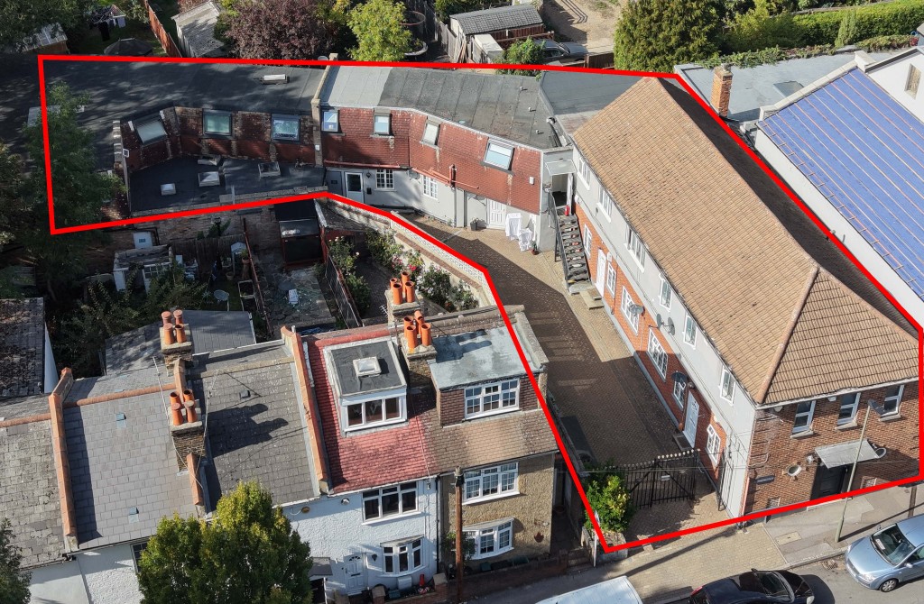 Lot: 155 - SUBSTANTIAL GATED FREEHOLD RESIDENTIAL INVESTMENT COMPRISING 14 FLATS - Drone image from south